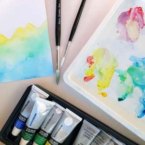 Watercolour paints, brushes, palette and painting